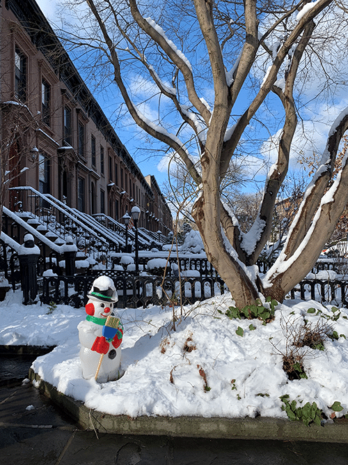 front yard of brownstone home with snowman in the snow in Carroll Gardens, Brooklyn